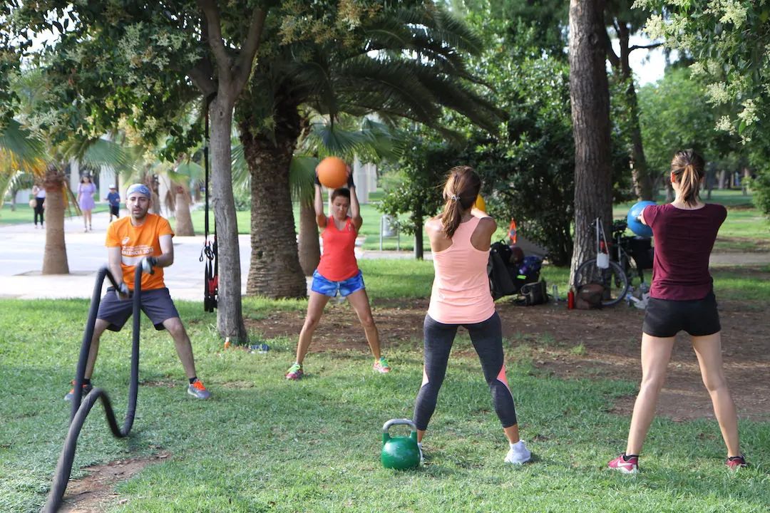 Grupo entrenando con kettlebell, balón medicinal y cuerda en el antiguo cauce del Turia